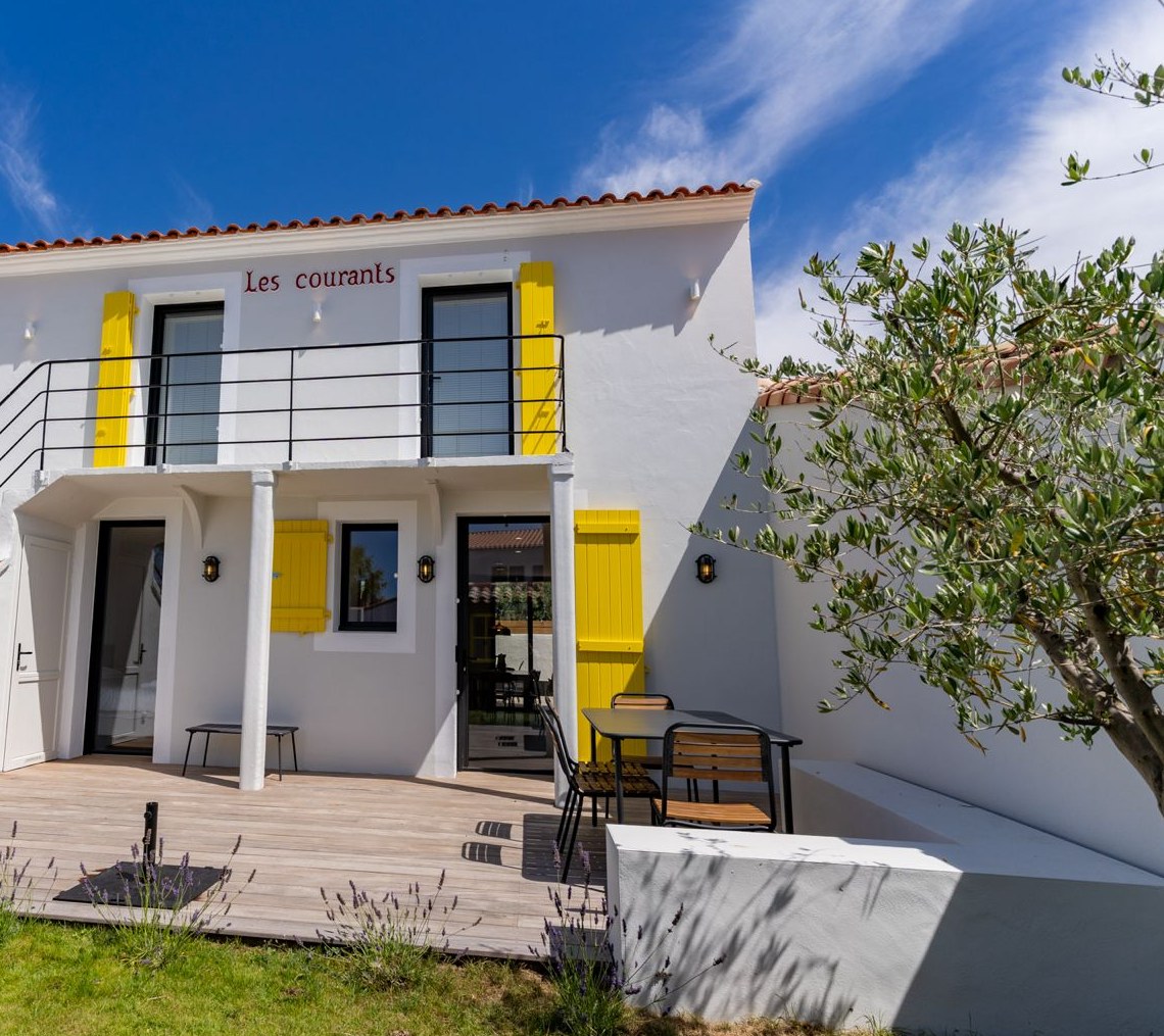 The house from the terrace, white facade and yellow shutters